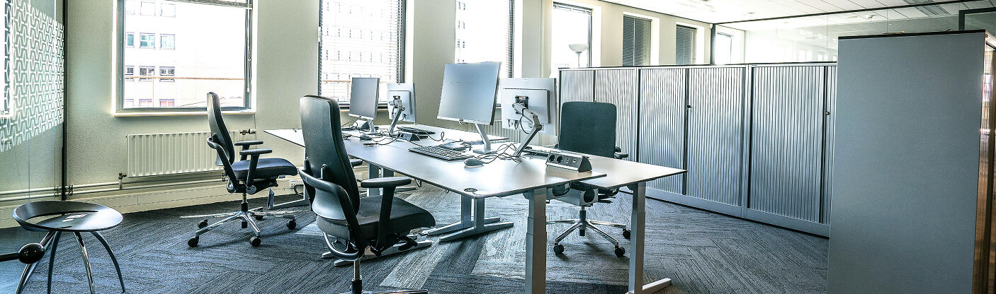 weiträumiges Büro mit Computern, grosse, helle Fenster