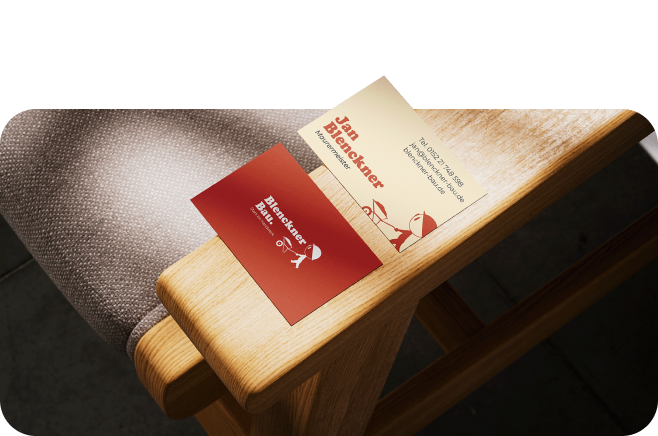 Visitenkarten Vorder und Rückseite von Blenckner Bau. Liegen auf Stuhllehne. Obere Karte teilweise freigestellt